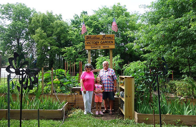 Bill Whitlow, right, his wife, Laurie, and their granddaughter, Ava, stand in front of Bill's vegetable garden. Though the sign and raised beds are new, the patch has been gardened by the Whitlow family since 1910, Bill said.