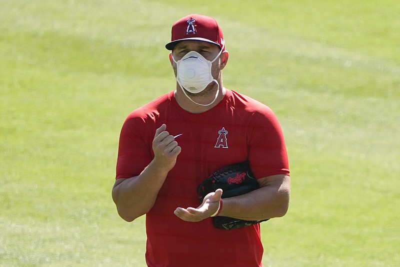 Los Angeles Angels center fielder Mike Trout (27) stands on the field wearing a face mask during a baseball practice at Angels Stadium on Friday, July 3, 2020, in Anaheim, Calif. (AP Photo/Ashley Landis)