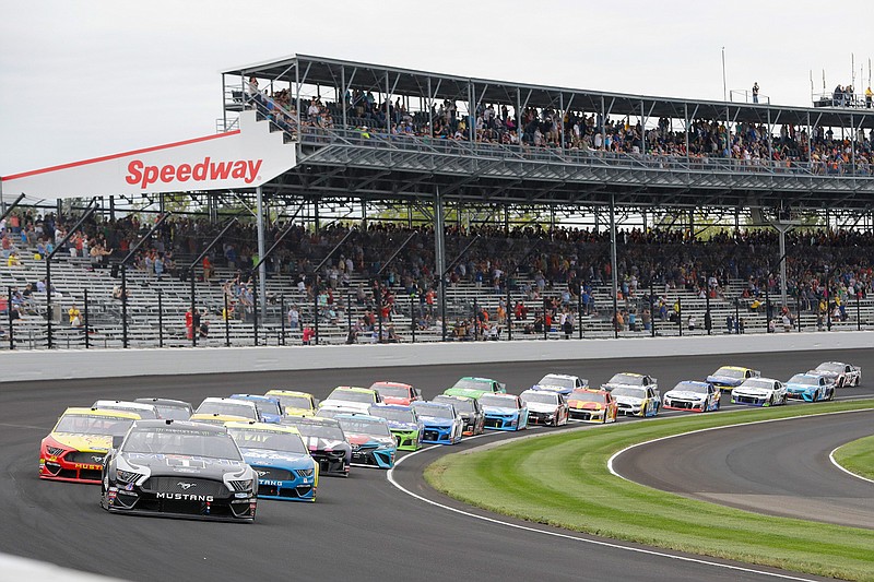 In this Sept. 8, 2019, file photo, Kevin Harvick leads the field through the first turn on the start of the NASCAR Brickyard 400 auto race at Indianapolis Motor Speedway in Indianapolis. The once frosty schism between the two biggest racing series in the United States has thawed and NASCAR's elite Cup Series will share a venue with IndyCar on the same weekend for the first time in history. (AP Photo/Darron Cummings, File)