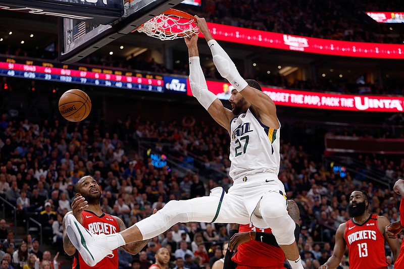 In this Feb. 22, 2020, file photo, Utah Jazz's Rudy Gobert (27) dunks during the second half of an NBA basketball game against the Houston Rockets in Salt Lake City. Gobert is standing tall, even after having coronavirus and dealing with an enormous amount of scorn after being diagnosed. He was the first NBA player to test positive for the virus and that prompted many to blame him for the league's shutdown in response to the pandemic. (AP Photo/Kim Raff, File)