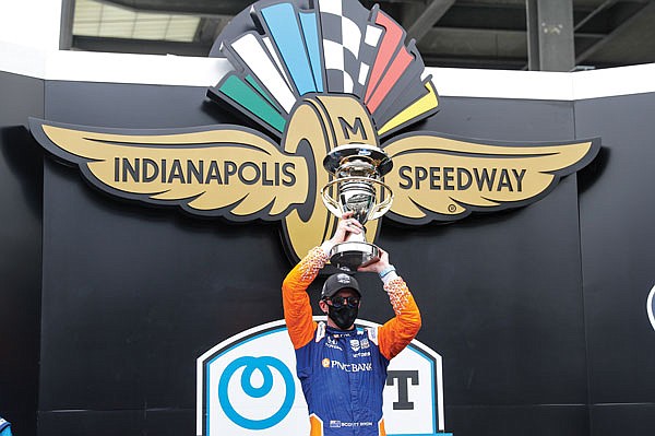 Scott Dixon celebrates with the trophy Saturday after winning the IndyCar race at Indianapolis Motor Speedway in Indianapolis.