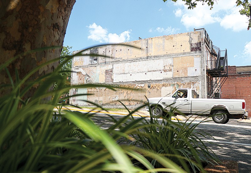 A truck drives past the exposed exterior of 202 E. High St., where the building of 200 E. High St. once stood. A June 6, 2019, ruling declaring the demolition of 200 E. High St. Demolition construction began in March of this year.