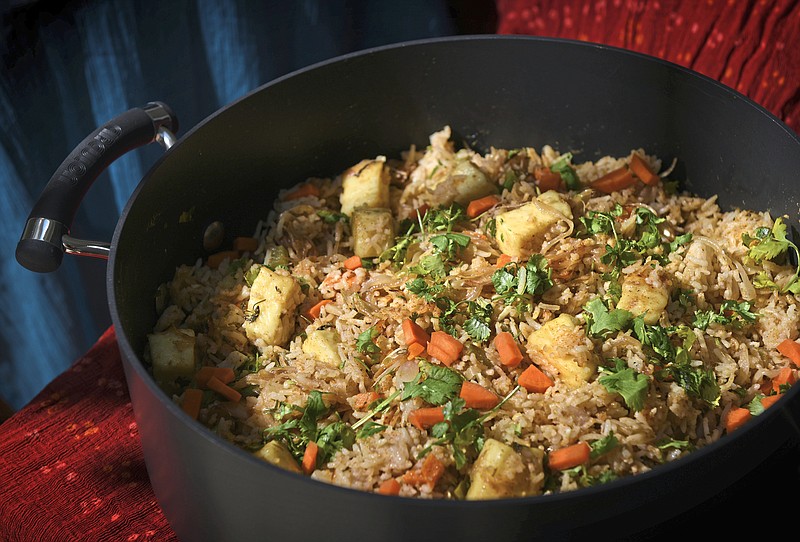 Paneer biryani, studded with Indian cheese cubes, carrots and green pepper, is made in a Dutch oven on the stovetop. Long-grain basmati rice is used in this biryani. (Steve Mellon/Pittsburgh Post-Gazette/TNS) 