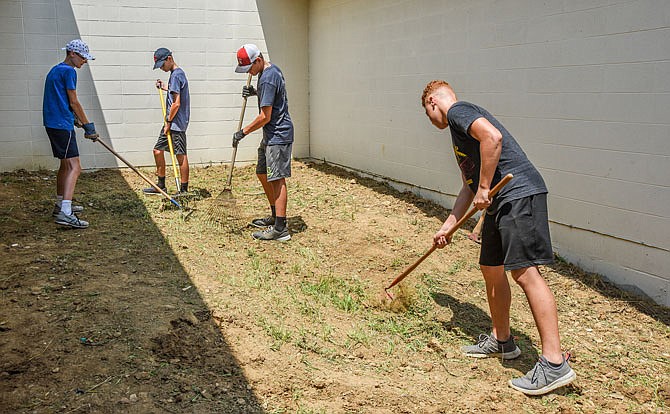 So they can remain close to home during the COVID-19 pandemic, pastors and youth from First Baptist Church in downtown Jefferson City are doing their missionary work at Community Christian Church, helping to restore and prepare a yard area for planting. From left, Xander Schmid, Cody Pickett, Doug Blaha Jr. and Zeke Duren, all 14, dig out clumps of grass and smooth out the dirt as they prepare for planting on the backside of the Ellis Boulevard church.