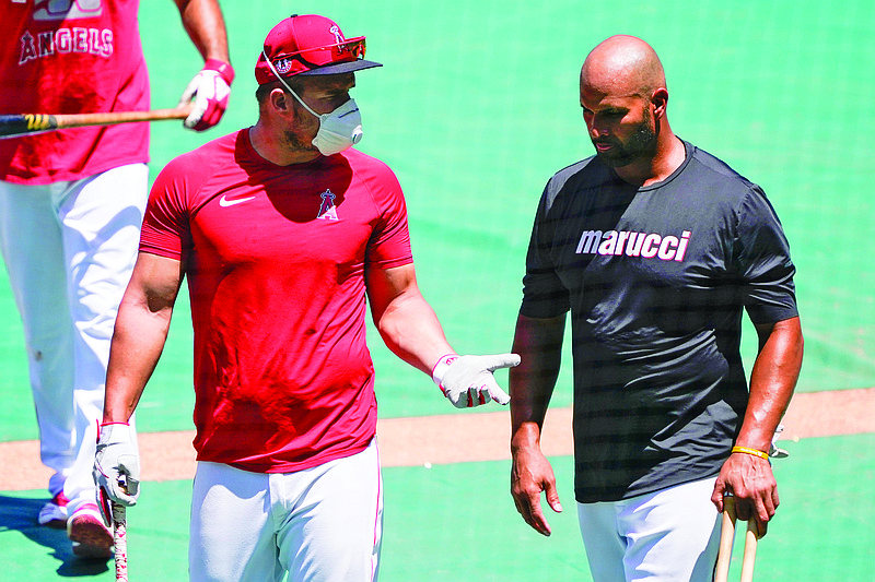 Angels center fielder Mike Trout (left) talks with first baseman Albert Pujols during Wednesday's practice at Angel Stadium in Anaheim, Calif.
