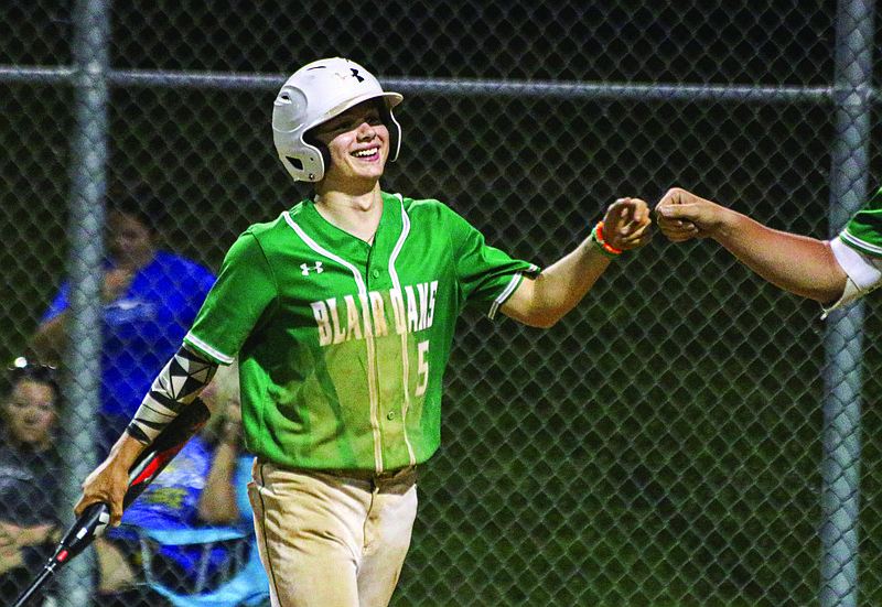 Cole Jungmeyer of Blair Oaks fist bumps a teammate after scoring a run during the second game of Tuesday night's doubleheader against Capital City at the Falcon Athletic Complex in Wardsville.