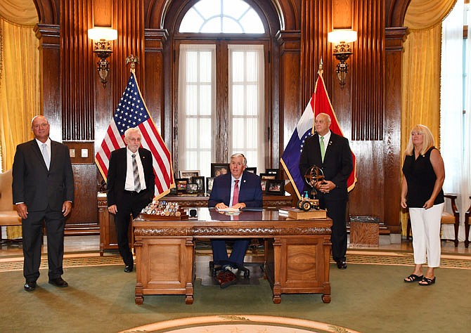 Gov. Mike Parson signs House Bill 1330, which transfers 116 acres of state-owned land to the Heartland Port Authority for a Missouri River port in Jefferson City, on Tuesday in his office. He is accompanied by, from left, state Sen. Mike Bernskoetter, state Rep. Rudy Veit, state Rep. Dale Wright and state Rep. Becky Ruth.