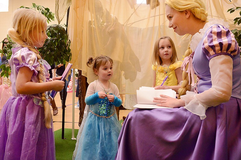 FILE PHOTO: From left, Logan Slippin, 4, Clair Brown, 3, and Kalla Brown, 5, meet Rapunzel on Nov. 23, 2019, as she signs their signature books during A Princess Party at First United Methodist Church. 