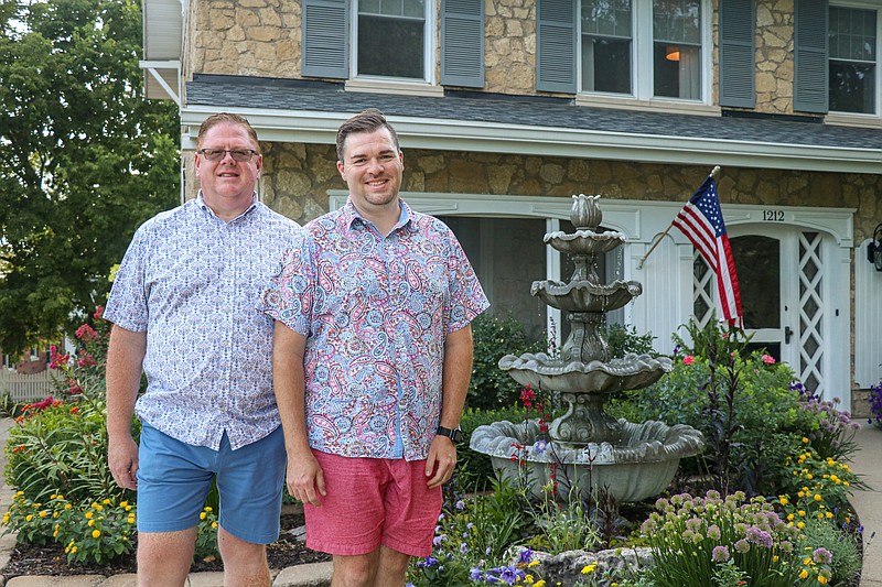 Greta Cross/ News Tribune
Alan Wheat, left, and Chase Batye, right, smile outside their home at 1212 Moreau Drive. Wheat and Batye were awarded the Bittersweet Garden Club garden of the month award for June. Typically, the garden of the month award begins in May, but due to COVID-19 the summer series was delayed. Their home is over 100 years old, with stones from the first Missouri State Capitol laying in their front yard.
