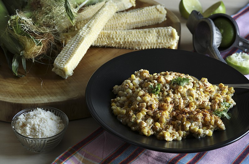 Corn lightly spread with mayo and then grilled is mixed with lime juice, cojita cheese and ground chiles. (Abel Uribe/Chicago Tribune/TNS)