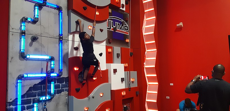 A young adventurer ascends the climbing wall at iJump, one of several features at the park. Though the concept of iJump is a trampoline park, more activities are available, of which the climbing wall is one.