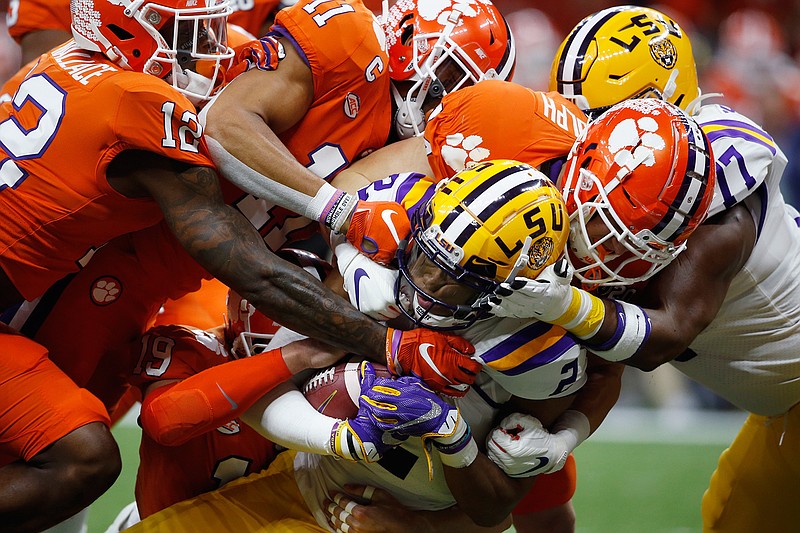  In this Jan. 13, 2020, file photo, LSU wide receiver Justin Jefferson (2) is tackled by Clemson during the first half of an NCAA College Football Playoff national championship game in New Orleans. The NCAA's latest guidance for playing college sports during the COVID-19 pandemic recommends testing players once a week within 72 hours of competition. For typical Saturday football games, that means Wednesday would be the soonest athletes would be tested.
Is that enough for a team of about 100 athletes playing a contact sport to get through a season without major disruptions? Especially, considering simply being exposed to someone who tests positive can land an athlete in quarantine for two weeks? (AP Photo/Gerald Herbert, File)