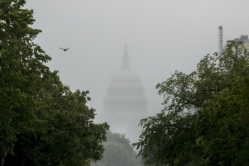 FILE - In this May 22, 2020, file photo the Dome of the U.S. Capitol Building is visible through heavy fog in Washington. With COVID-19 cases hitting alarming new highs and a grim rising death toll, the pandemic's devastating cycle is happening all over again, leaving Congress little choice but to engineer another costly rescue. (AP Photo/Andrew Harnik, File)