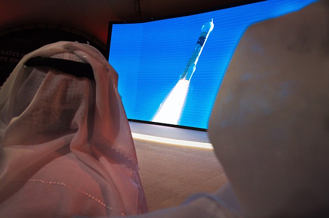 Emirati men watch the launch of the "Amal" or "Hope" space probe at the Mohammed bin Rashid Space Center in Dubai, United Arab Emirates, Monday, July 20, 2020. A United Arab Emirates spacecraft, the "Amal" or "Hope" probe, blasted off to Mars from Japan early Monday, starting the Arab world's first interplanetary trip. (AP Photo/Jon Gambrell)