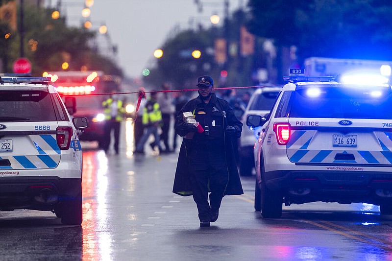 Chicago police investigate the scene of a mass shooting where more then a dozen people were shot in the Gresham neighborhood, of Chicago, Tuesday, July 21, 2020. (Tyler LaRiviere/Chicago Sun-Times via AP)