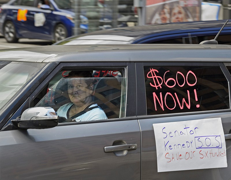 Motorists take part in a caravan protest in front of Senator John Kennedy's office at the Hale Boggs Federal Building asking for the extension of the $600 in unemployment benefits to people out of work because of the coronavirus in New Orleans, La. Wednesday, July 22, 2020. (Max Becherer/The Advocate via AP)