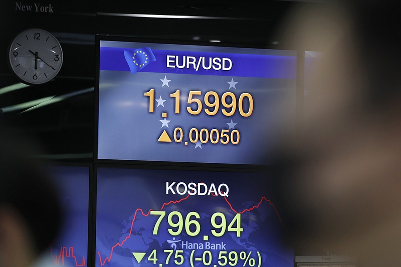 A currency trader watches computer monitors near screens showing the Korean Securities Dealers Automated Quotations (KOSDAQ) and the foreign exchange rate at the foreign exchange dealing room in Seoul, South Korea, Friday, July 24, 2020. Worsening China-U.S. friction, worries over aid to Americans and U.S. businesses and a stumble on Wall Street combined to push shares in Asia lower on Friday. (AP Photo/Lee Jin-man)
