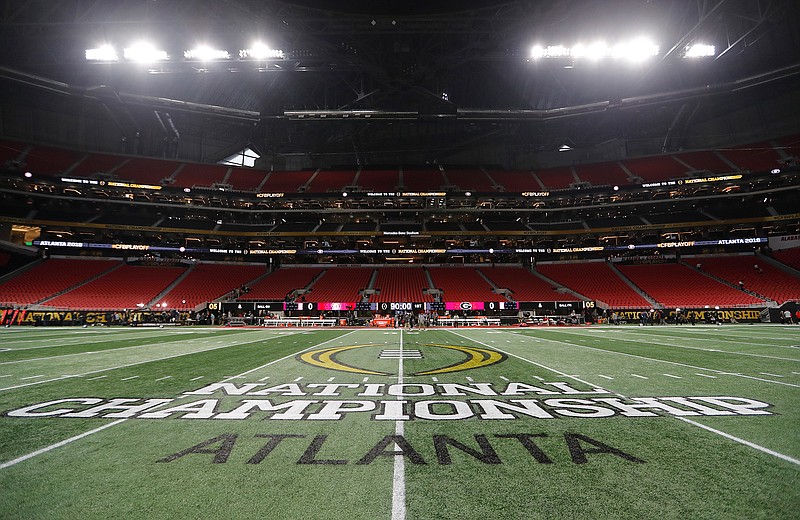 In this Jan. 8, 2018, file photo, the championship logo is seen on the field at Mercedes-Benz Stadium before the NCAA college football playoff championship game between Georgia and Alabama in Atlanta. There are more bowl games scheduled for the coming season than ever before in major college football: 42, not including the College Football Playoff championship. College football leaders are in the process of piecing together plans to attempt to play a regular season during the COVID-19 pandemic. If it is even possible, everyone anticipates there will be disruptions, added expenses and loads of stress just to get through it.(AP Photo/David Goldman)