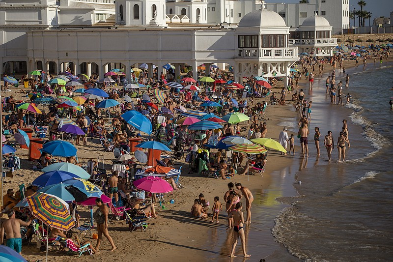 Bathers enjoy the beach in Cadiz, south of Spain, on Friday, July 24, 2020. With the coronavirus rebounding in parts of Spain, it appears that several regions have not adequately prepared to trace new infections in what was supposed to be an early detection system to prevent a new cascade of cases. (AP Photo/Emilio Morenatti)