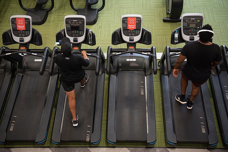 Gym members exercise between 'do not use' machines Saturday at PureGym in Leamington Spa, England. Fitness gyms are allowed to admit members of the public for the first time since the national lockdown, reopening as Indoor gyms, swimming pools and sports facilities can reopen as part of the latest easing of coronavirus lockdown measures in England. 