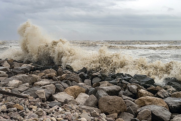 Gulf water comes crashing over the rocks and seawall spilling onto Texas State Highway 87 on Saturday morning, July 25, 2020, on the Bolivar Peninsula, in Texas. Even though Hurricane Hanna made landfall several hundred miles south of the Bolivar Peninsula, the storm still had an effect on the area. (Fran Ruchalski/The Beaumont Enterprise via AP)