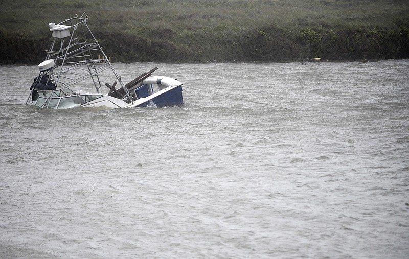 A boat sinks in the Packery Channel during Hurricane Hanna, Saturday, July 25, 2020, in North Padre Island, Texas. The Category 1 storm continued to strengthen before reaching Padre Island at 5 p.m. Saturday. (Annie Rice/Corpus Christi Caller-Times via AP)
