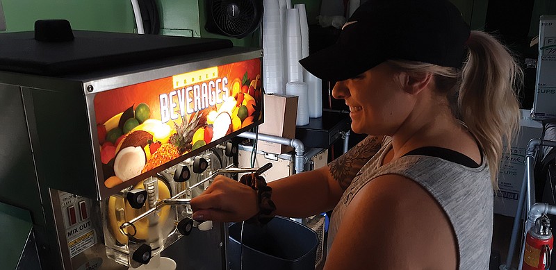 Kasey Fant serves up cold drinks at Frozen Rail, the downtown caboose turned bar. Crowds have been showing up for the various concoctions. At this time of the year that means lots of cold, frozen drinks as well as cold beer.