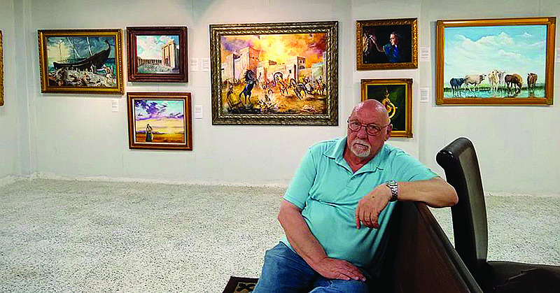 Danny Helms poses with his art exhibit, "Led by the Spirit," on display at the 1894 Gallery in downtown Texarkana. Each painting is inspired by a book of the Old Testament.