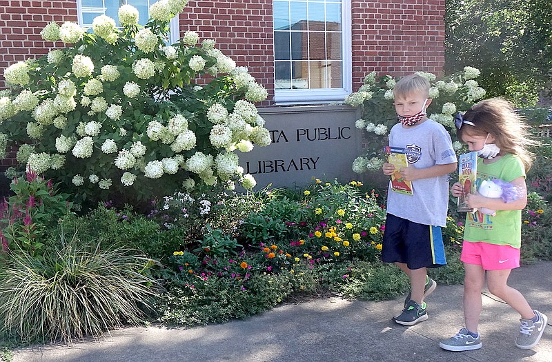  It's hot and humid but Evan Wicks, 6, and his sister Elizabeth, 4, are happily visiting the Atlanta Public Library, which has air conditioning. Everyone is welcomed by these flourishing flowers in the garden outside by the building's nameplate. They are maintained by a Friends of the Library volunteer who prefers to remain anonymous.