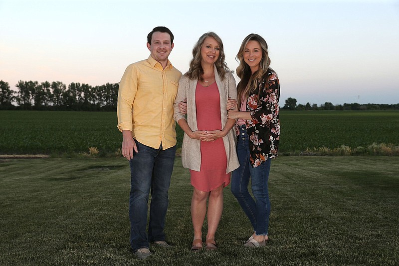 Julie Loving, center, poses for photographs with her son-in-law, Aaron Lockwood, and her daughter, Breanna Lockwood, at the Lockwood home on June 18, 2020, in Manteno. Loving, 51, is carrying her daughter and son-in-law's baby as a surrogate, due in November. (John J. Kim/Chicago Tribune/TNS)