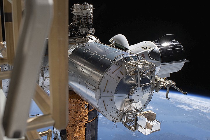 This July 1, 2020 photo made available by NASA shows the SpaceX Crew Dragon, right, docked to the International Space station, during a spacewalk conducted by astronauts Bob Behnken and Chris Cassidy. On Wednesday, July 29, 2020, SpaceX and NASA cleared the Dragon crew capsule to depart the International Space Station and head home after a two-month flight. (NASA via AP)