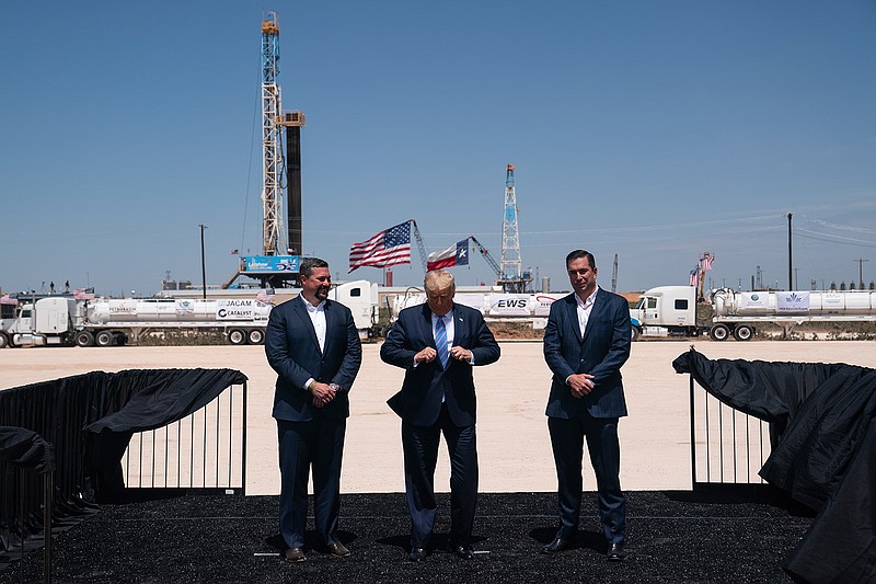 President Donald Trump adjusts his jacket as he stands with Double Eagle Energy co-CEOs Cody Campbell, left, and John Sellers, right before viewing the Double Eagle Energy Oil Rig, Wednesday, July 29, 2020, in Midland, Texas. (AP Photo/Evan Vucci)