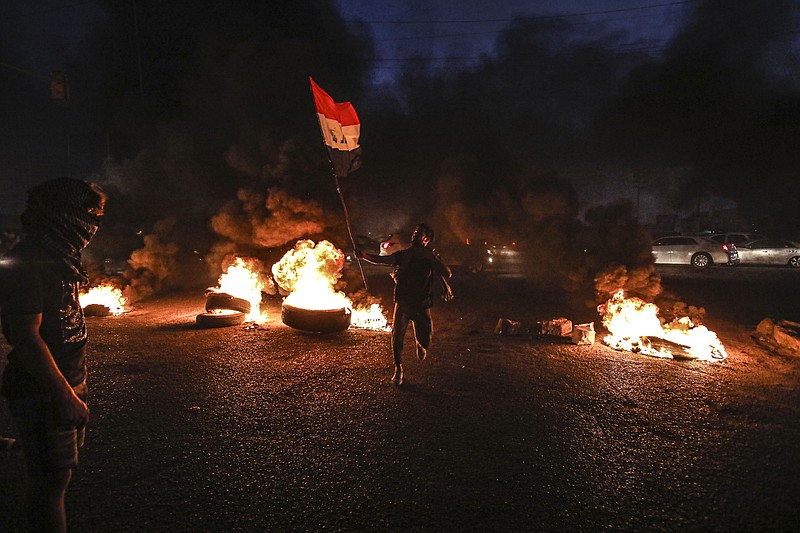 Protesters burn tires during a demonstration demanding better public services and jobs in Basra, southeast of Baghdad, Iraq, Monday, July 27, 2020. (AP Photo/Nabil al-Jurani)