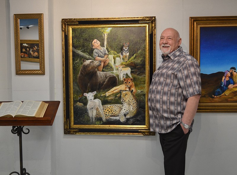 Danny Helms poses with his favorite of the 39 paintings depicting the books of the Old Testament. The collection is in the biggest of the new viewing rooms until Sept. 30. (Photo by Kate Stow)