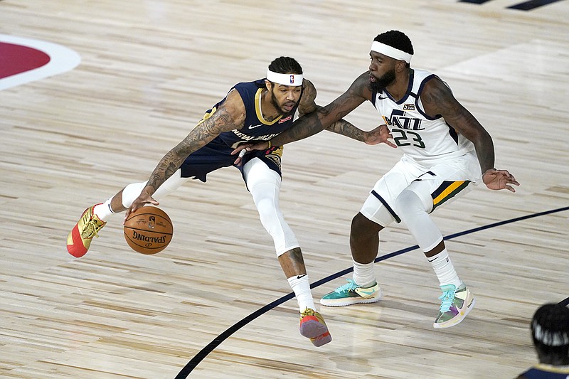 Brandon Ingram of the Pelicans dribbles around Royce O'Neale of the Jazz during Thursday night's game in Lake Buena Vista, Fla.