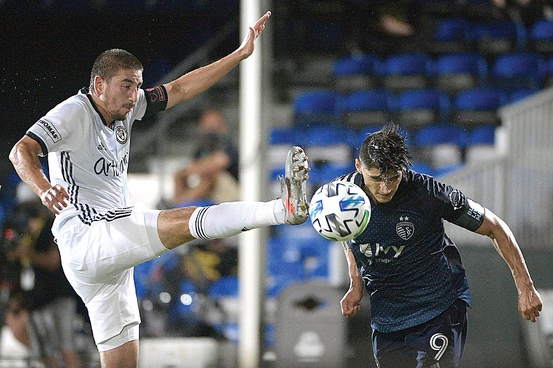 Sporting Kansas City forward Alan Pulido scores a goal on a header as Philadelphia Union midfielder Alejandro Bedoya defends during the first half of Thursday night's match in Lake Buena Vista, Fla.