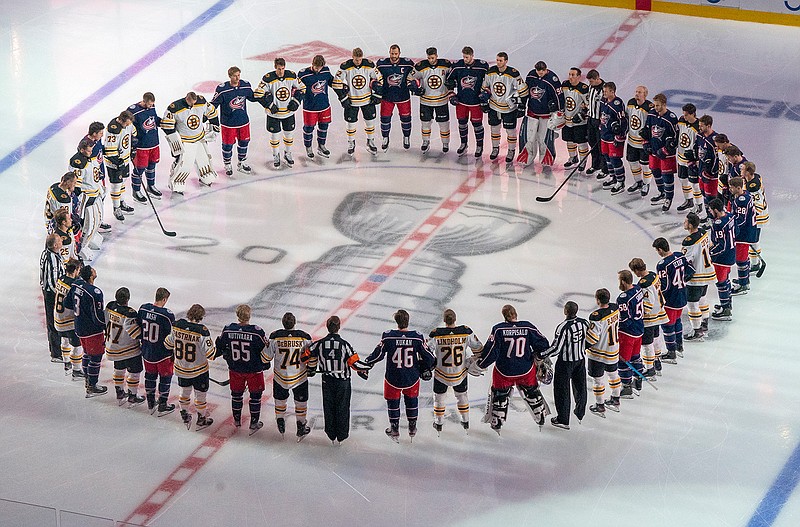 The Boston Bruins and the Columbus Blue Jackets stand together for the national anthems prior to NHL hockey exhibition game action in Toronto, Thursday, July 30, 2020. (Frank Gunn/The Canadian Press via AP)