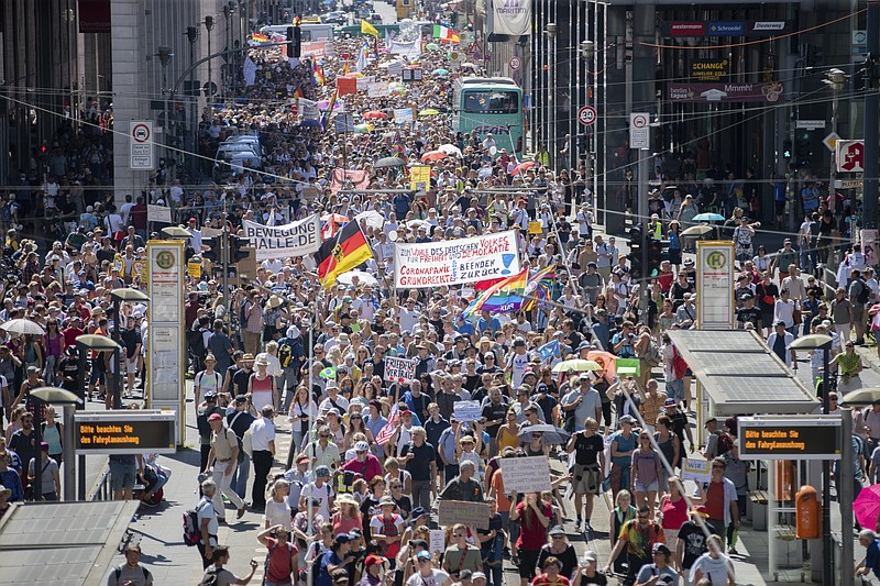 Thousands march along the 'Friedrichstrasse' during the demonstration against corona measures in Berlin, Germany, Saturday, Aug. 1, 2020. The initiative "Querdenken 711" has called for this. The motto of the demonstration is "The end of the pandemic - Freedom Day". (Christoph Soeder/dpa via AP)