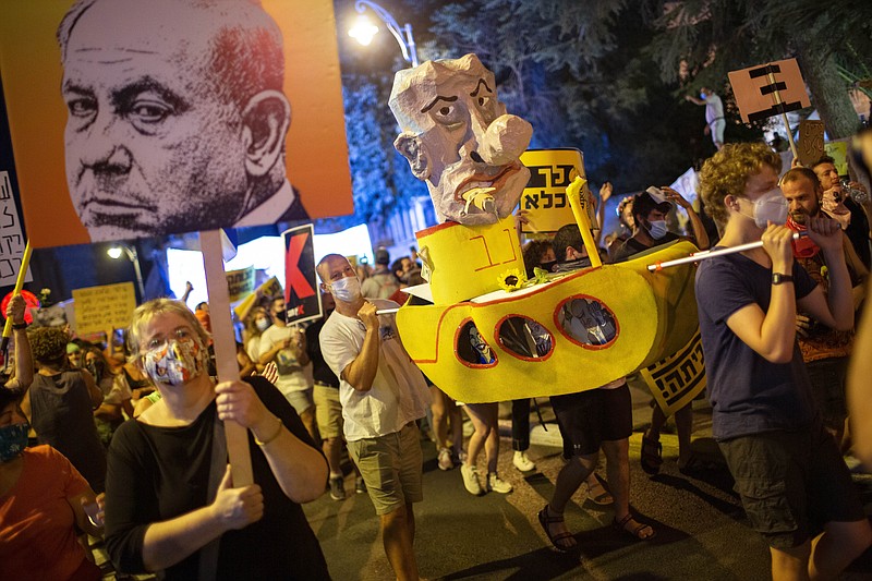 Demonstrators chant slogans and hold signs during a rally against Israel's Prime Minister Benjamin Netanyahu outside his residence in Jerusalem, Saturday, Aug 1, 2020. Protesters demanded that the embattled Israeli leader to resign as he faces a trial on corruption charges and grapples with a deepening coronavirus crisis. (AP Photo/Oded Balilty)
