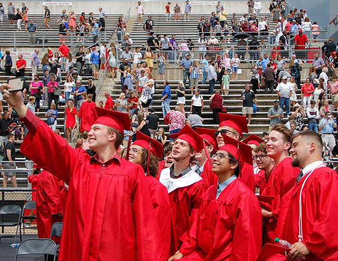 Members of the Class of 2020 embrace for a selfie Saturday after their long-awaited commencement ceremony at Adkins Stadium.