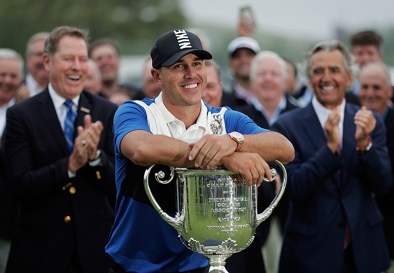 In this May 19, 2019, file photo, Brooks Koepka poses with the Wanamaker Trophy after winning the PGA Championship golf tournament at Bethpage Black in Farmingdale, N.Y. Koepka will try to become the first player to win the PGA Championship three straight times in stroke play starting Aug. 6, 2020, and there will not be anyone at Harding Park to cheer him on. (AP Photo/Julio Cortez, FIle)