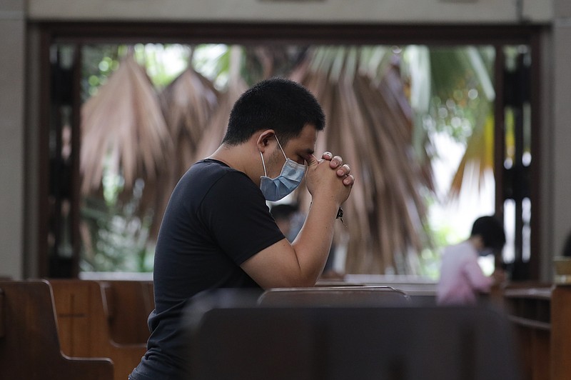 A man prays with only a few other parishioners Sunday as a measure to prevent the spread of COVID19 during Mass at the Our Lady of Consolation Parish in Quezon city, Philippines. Coronavirus infections in the Philippines continues to surge Sunday as medical groups declared the country was waging a losing battle against the contagion and asked the president to reimpose a lockdown in the capital. (AP Photo/Aaron Favila)