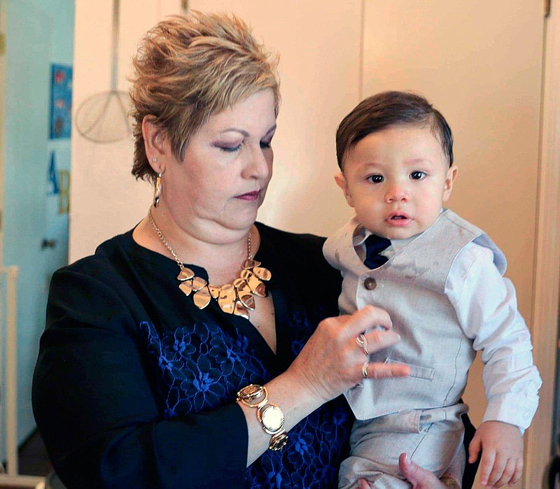 In this photo provided by Tito Anchondo, Paul Anchondo is held by his grandmother, Brenda Anchondo, on May 23 in El Paso, Texas. The toddler is unlikely to learn until years from now what happened to his parents in events that many El Paso residents still struggle to comprehend, said uncle Tito Anchondo, whose brother Andre and sister-in-law Jordan died in the shooting at a Walmart store last year.