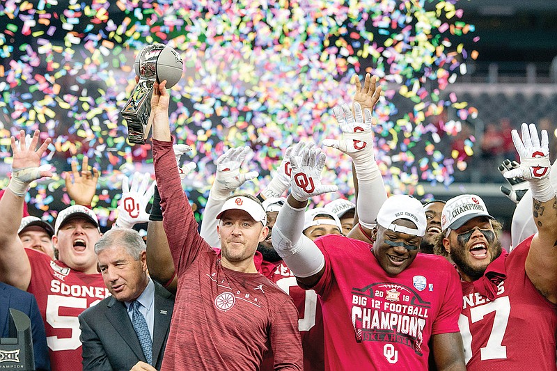 In this Dec. 7, 2019, file photo, Oklahoma head coach Lincoln Riley hosts the Big 12 Conference title trophy after defeating Baylor 30-23 in overtime in Arlington, Texas.