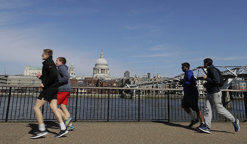 FILE - In this file photo dated  Sunday, March 22, 2020, people run to keep fit along the south bank of the River Thames in London.  European Union regulators have said Tuesday Aug, 4, 2020, they're opening an in-depth investigation into U.S. tech giant Google's plan to buy fitness tracking device maker Fitbit. (AP Photo/Kirsty Wigglesworth, FILE)