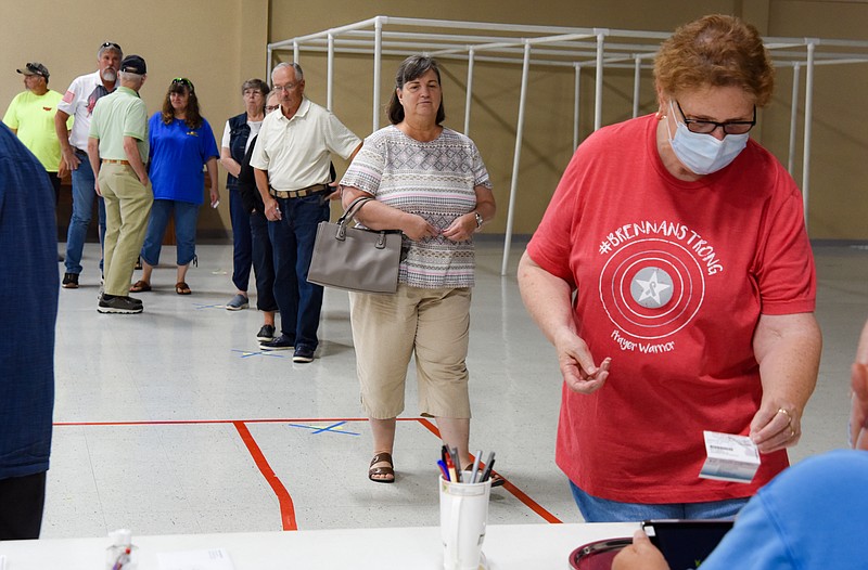 Neta Meyer approaches a polling place judge to request a ballot Tuesday while voting at Capital West Christian Church Event Center on Fairgrounds Road. The polling judges had a steady stream of voters and at times, saw a dozen or more people waiting in line. People waiting to vote observed social distancing rules, with nearly everyone wearing a mask. Julie Smith/News Tribune