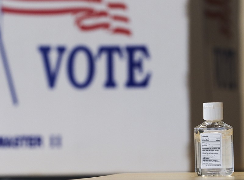 A small bottle of hand sanitizer sits on a table in front of a row of voting booths on Tuesday at The Linc. Sanitizer could be found on check in tables around the room to promote cleanliness in the age of the coronavirus pandemic. Liv Paggiarino/News Tribune