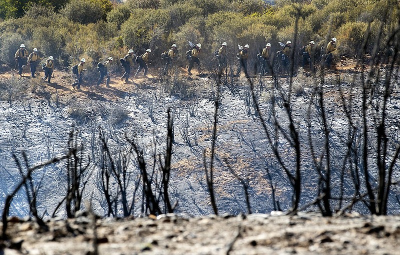 Wildland firefighters work a line to douse hot spots along Avenida Miravilla in Cherry Valley, Calif. (Gina Ferazzi/Los Angeles Times/TNS) 