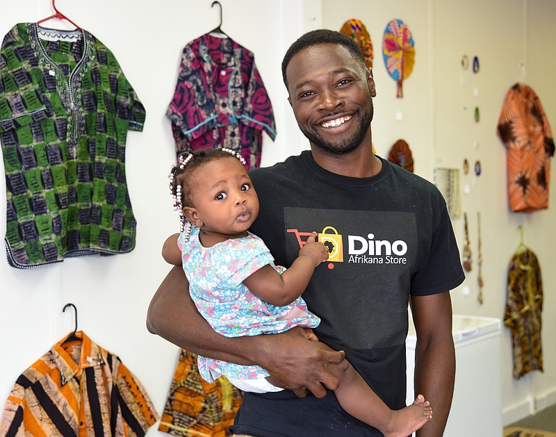 Julie Smith/News Tribune
 Ahmed Alli holds his 10-month old daughter Anyla Alli in his retail shop, Dino Afrikana, located on Industrial Drive. The recently opened shop features ethnic foods and as sales grow, Alli plans to increase the selection.