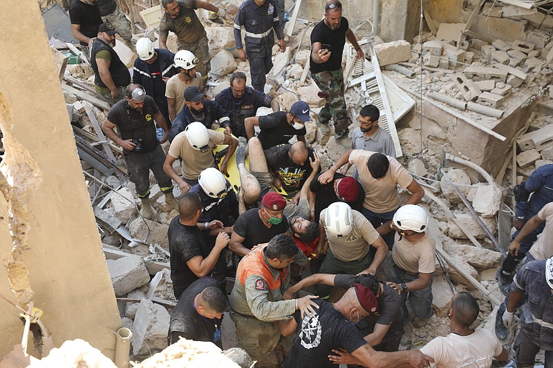 A survivor is taken out of the rubble after a massive explosion in Beirut, Lebanon, Wednesday, Aug. 5, 2020. The explosion flattened much of a port and damaged buildings across Beirut, sending a giant mushroom cloud into the sky. In addition to those who died, more than 3,000 other people were injured, with bodies buried in the rubble, officials said.(AP Photo/Hassan Ammar)